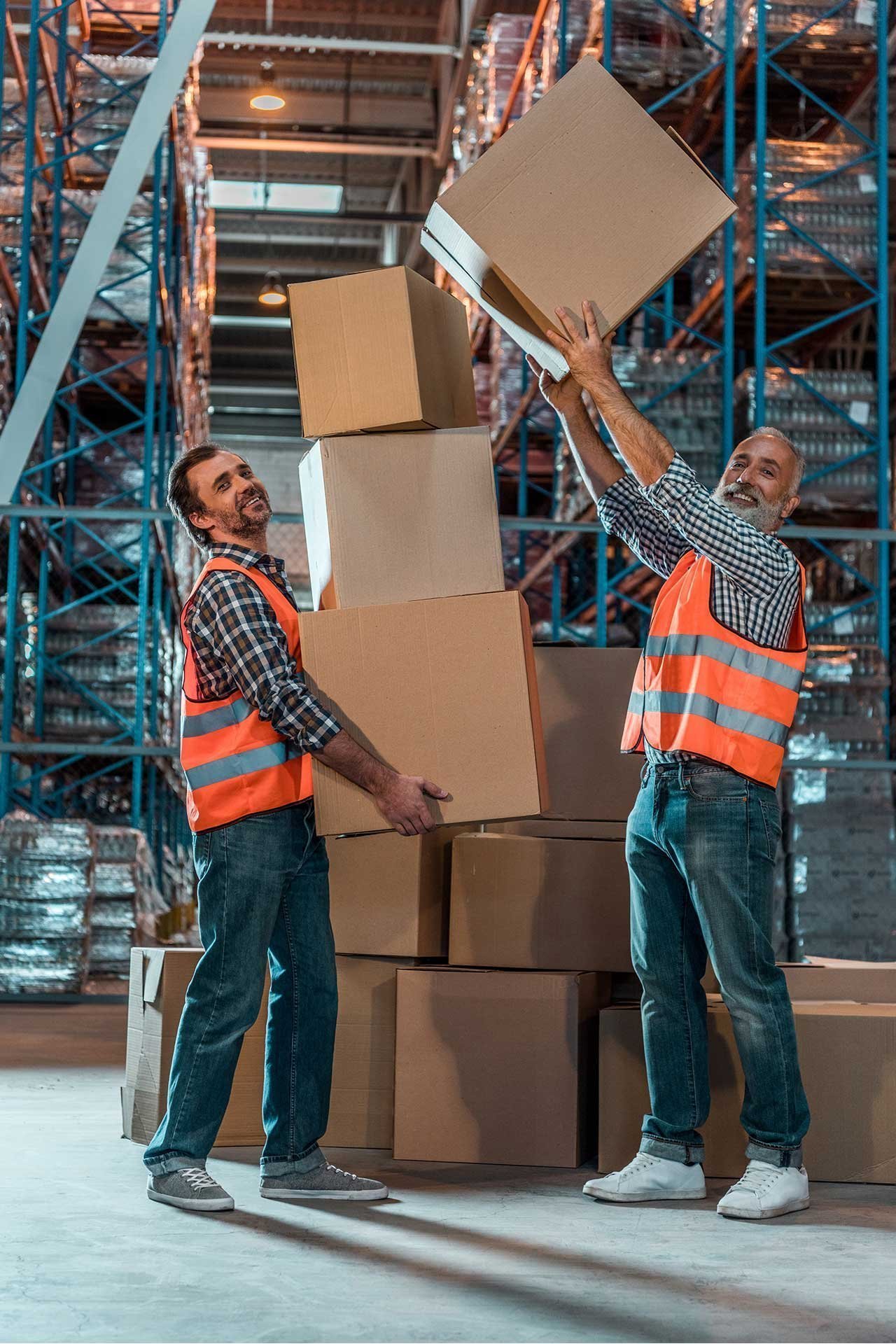 smiling warehouse workers holding stacked boxes an 2023 11 27 05 18 45 utc 1